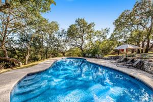 a swimming pool with blue water in a yard at Stargazer Ridge in Dripping Springs