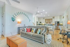 a living room with a couch and a kitchen at Tradewinds in Folly Beach