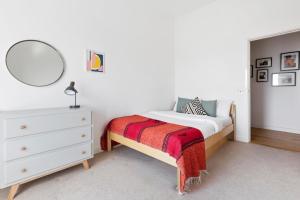 a bedroom with a bed with a mirror and a dresser at Stunning 2 Bedroom Apartment in Dalston in London