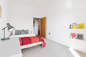 a white bedroom with a bed and a lamp at Stunning 2 Bedroom Apartment in Dalston in London