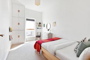 a white bedroom with a bed and a mirror at Stunning 2 Bedroom Apartment in Dalston in London