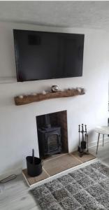 a living room with a fireplace with a tv above it at Modern Single room for rental in Colchester Town Centre! in Colchester