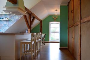 a kitchen with green walls and a bar with chairs at Apartment, Karft in Karft