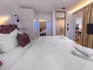 a bedroom with a large white bed with a mirror at Apartments B-HOME, Bramberg am Wildkogel in Bramberg am Wildkogel