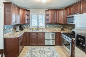 a kitchen with wooden cabinets and stainless steel appliances at Belleville Beauty - Luxury Stay for Work or stay for Play either way this is the perfect property for you! residence in Belleville