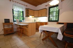 a kitchen with a table and some chairs and windows at Semi detached house, Glave in Glave