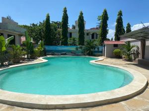 a swimming pool in a yard with trees at Mudzini gardens - Luxury villa with a pool in Mombasa