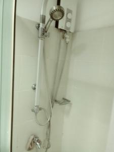 a shower with a shower head in a bathroom at MOA Rental in Manila