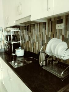 a kitchen counter with a sink and plates on it at MOA Rental in Manila
