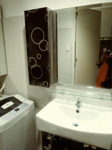 a white bathroom with a sink and a mirror at MOA Rental in Manila