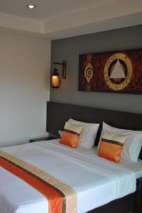 a bedroom with two beds with orange and white pillows at Baan Kata Maytha in Kata Beach
