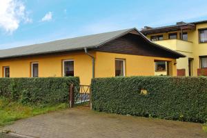 a yellow house with a hedge in front of it at Cottage, Zinnowitz in Zinnowitz