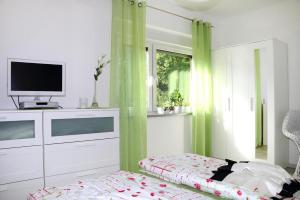 een slaapkamer met een bed, een televisie en een raam bij Apartment, Tambach-Dietharz in Tambach-Dietharz