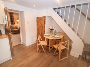 ein Esszimmer mit einem Tisch und einer Treppe in der Unterkunft The Cottage in Tetbury