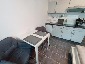 Una sala de estar con una mesa y una cocina. en BodenSEE Apartments Fischbach Eichenmühleweg, en Fischbach