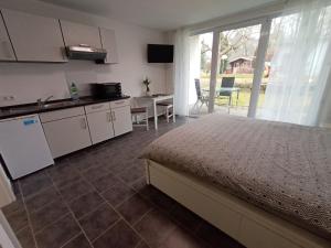 Un dormitorio con una cama y una cocina y una mesa. en BodenSEE Apartments Fischbach Eichenmühleweg, en Fischbach 6 fotos más