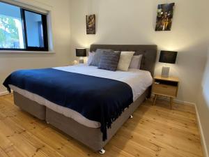 una camera da letto con un grande letto con una coperta blu di The Mitchell Bondi Garden 4 a Sydney