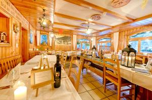 a dining room with a table with a bottle of wine at Pension Aaron am See in Grächen
