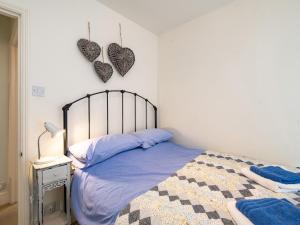 a bedroom with a bed with two hearts on the wall at Cobble Cottage in Boscastle