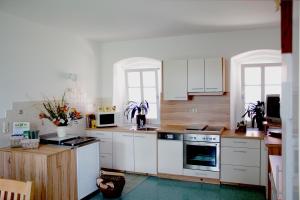 eine Küche mit weißen Schränken und weißen Geräten in der Unterkunft Ferienhaus Planetz in Kaindorf