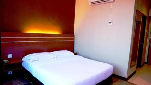 a bedroom with a white bed in a room at Best Star Resort in Pantai Cenang