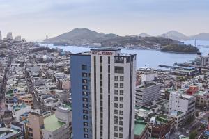 a tall building with a virgin agency sign on top of it at Hotel Kenny Yeosu in Yeosu