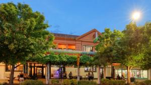 un bâtiment avec des arbres devant lui dans l'établissement Broadway Hotel, à Parkes