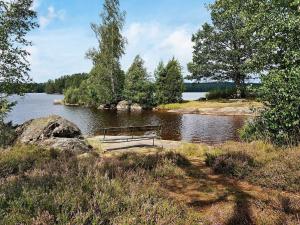 VirserumにあるHoliday Home Fritidsvägenの湖畔に座るベンチ