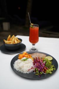 a plate of food with rice and vegetables and a drink at Blue Sky Beach Resort in Unawatuna