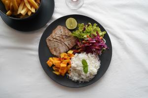 a plate of food with rice and meat and vegetables at Blue Sky Beach Resort in Unawatuna