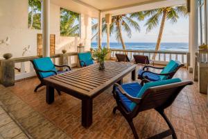 a dining room with a table and chairs and the ocean at Blue Sky Beach Resort in Unawatuna