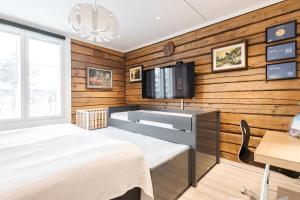 a bedroom with a bed and a tv on the wall at Villa Härmälä in Tampere