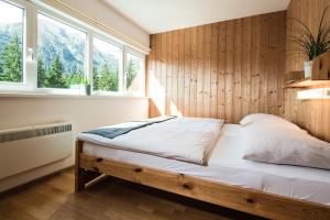 a bedroom with a bed with a wooden wall at Holiday village Pr bichl Vordernberg in Vordernberg