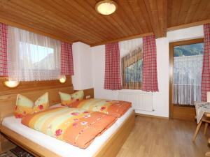 ein Schlafzimmer mit einem Bett und zwei Fenstern in der Unterkunft Apartment in Mayrhofen in the mountains in Mayrhofen