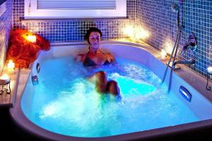 a man in a jacuzzi tub at night at Hesse farm holiday Borgo Pinete in Le Vedute