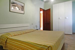 a bedroom with a bed with a yellow blanket on it at Hesse farm holiday Borgo Pinete in Le Vedute