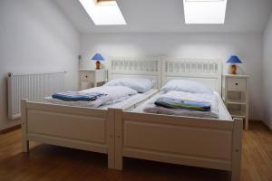 拉德施塔特的住宿－Landhaus Amadeus, Radstadt，一间白色卧室,配有两张床和两盏灯。