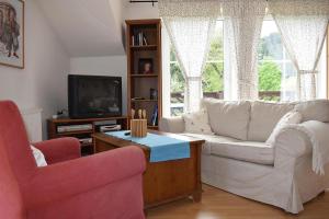 拉德施塔特的住宿－Landhaus Amadeus, Radstadt，客厅配有两把椅子和电视