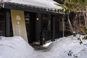 草津木叶酒店(Konoha)的前面有一堆积雪的建筑物