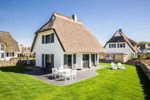 a large white house with a thatched roof at Holiday house, Fuhlendorf in Fuhlendorf