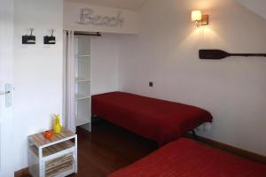 um pequeno quarto com uma cama vermelha e uma prateleira em Holiday Home Plougasnou - BRE05101j-F em Plougasnou