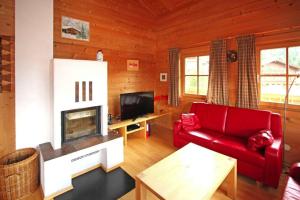 a living room with a red couch and a fireplace at Chalet, Königsleiten in Königsleiten