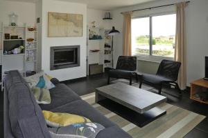 a living room with a couch and two chairs and a fireplace at Holiday Home in Plougasnou near Sandy Beach in Plougasnou