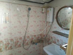 La salle de bains est pourvue d'une douche, d'un lavabo et d'un miroir. dans l'établissement ต้งโฮมหละปูน ณ ตูบแก้ว, à Lamphun