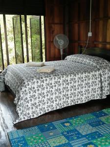 a bedroom with a bed and a fan on it at thesanctuary@telagapapan in Kampung Hulu Caluk