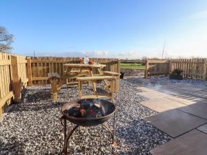a backyard with a fire pit and a picnic table at Lapwing Lodge in Lancaster