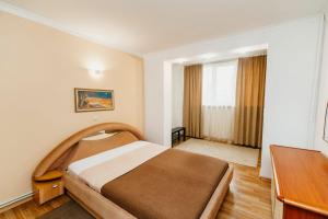 pokój hotelowy z łóżkiem i biurkiem w obiekcie Stefan cel Mare w Kiszyniowie