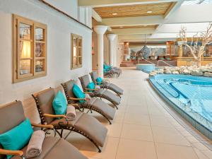 a swimming pool and lounge chairs in a hotel lobby at Parkhotel Bad Griesbach in Bad Griesbach