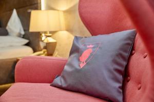 een kussen zittend op een rode stoel in een hotelkamer bij Parkhotel Bad Griesbach in Bad Griesbach