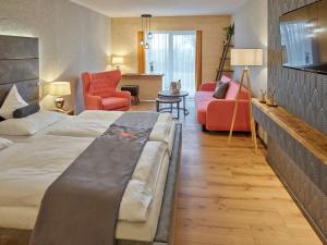 Habitación de hotel con cama y sala de estar. en Parkhotel Bad Griesbach, en Bad Griesbach